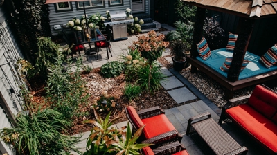 Patio with grill, daybed, plants, and patio furniture. Photo