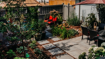 Patio with grill, daybed, plants, and patio furniture. Photo